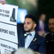 Virginia state Del. Ibraheem Samirah holds up a sign as Donald Trump delivers remarks during the 400th anniversary celebration of the first representative legislative assembly at Jamestown on July 30, 2019, in Jamestown, Va.